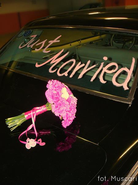 bukiet ślubny z goździków i napis na samochodzie do ślubu - just married