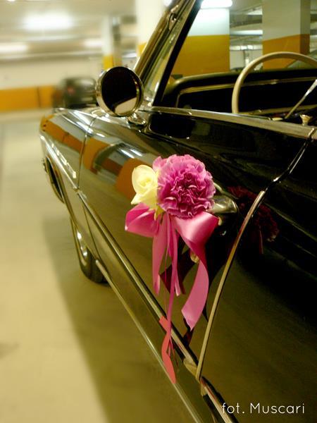 kwiaty i wstążki na klamce samochodu do ślubu