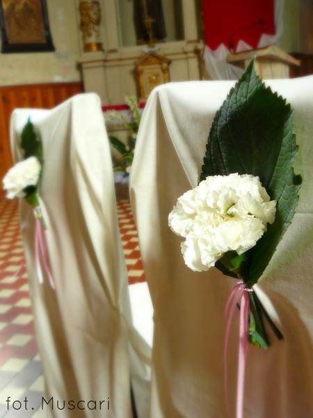 kwiaty i zieleń na krzesłach pary młodej w kościele