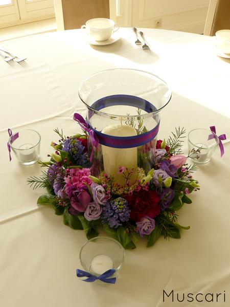 kwiaty i zieleń z lampionem - dekoracja okrągłego stołu