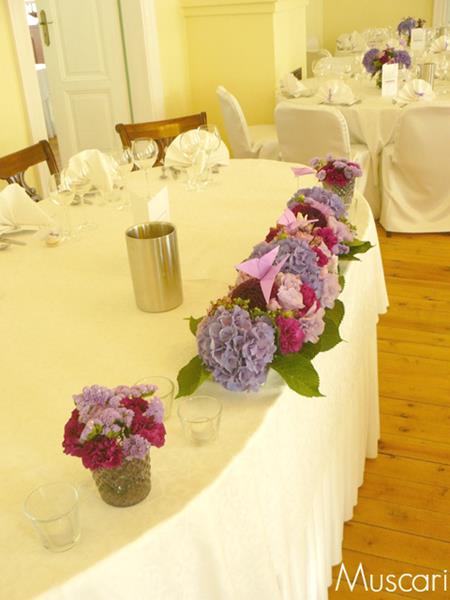 fioletowa kompozycja z kwiatów i ozdób na stole pary młodej