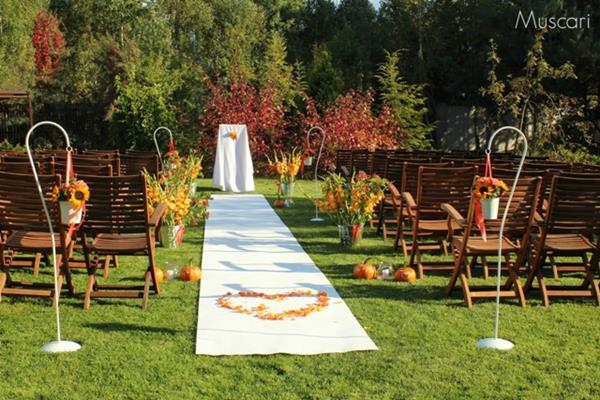 kwiaty w wiaderkach i na stojakach, dynie oraz biały dywan - ślub w ogrodzie
