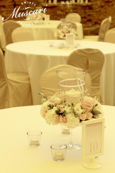 wianki z kwiatów i lampiony na stołach gości weselnych