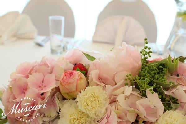 hortensje, róże, piwonie, goździki i zieleń w kompozycji na stole pary młodej