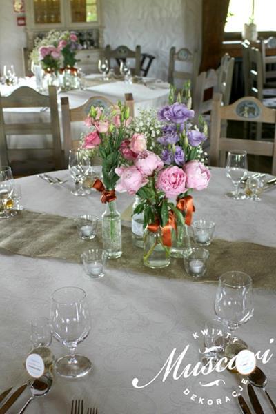 piwonie różowe, fioletowa eustoma i gipsówka w sielskiej aranżacji na stołach weselnych