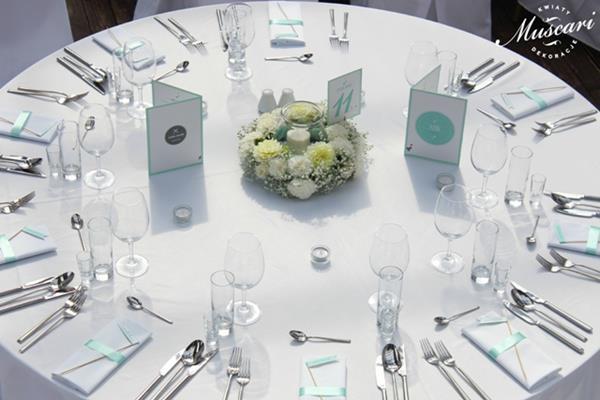 okrągły stół gości z wiankiem z kwiatów i miętowymi dodatkami
