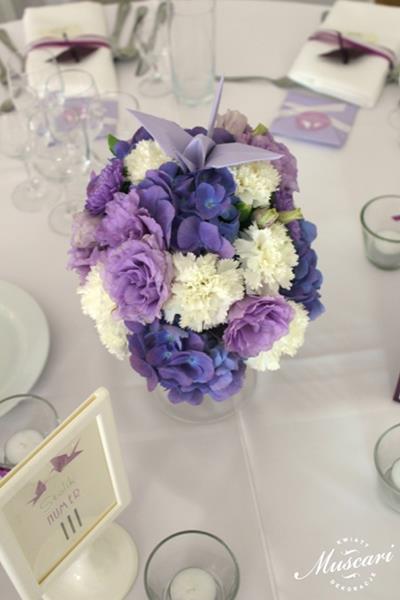 fioletowo-białe kwiaty na stole gości weselnych