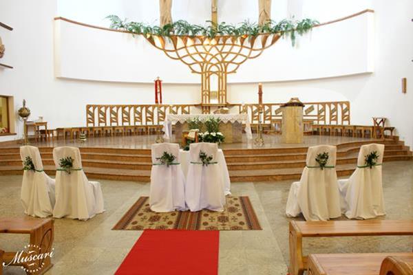 dekoracja w kościoła podczas ślubu - zieleń i białe nakrycia krzeseł