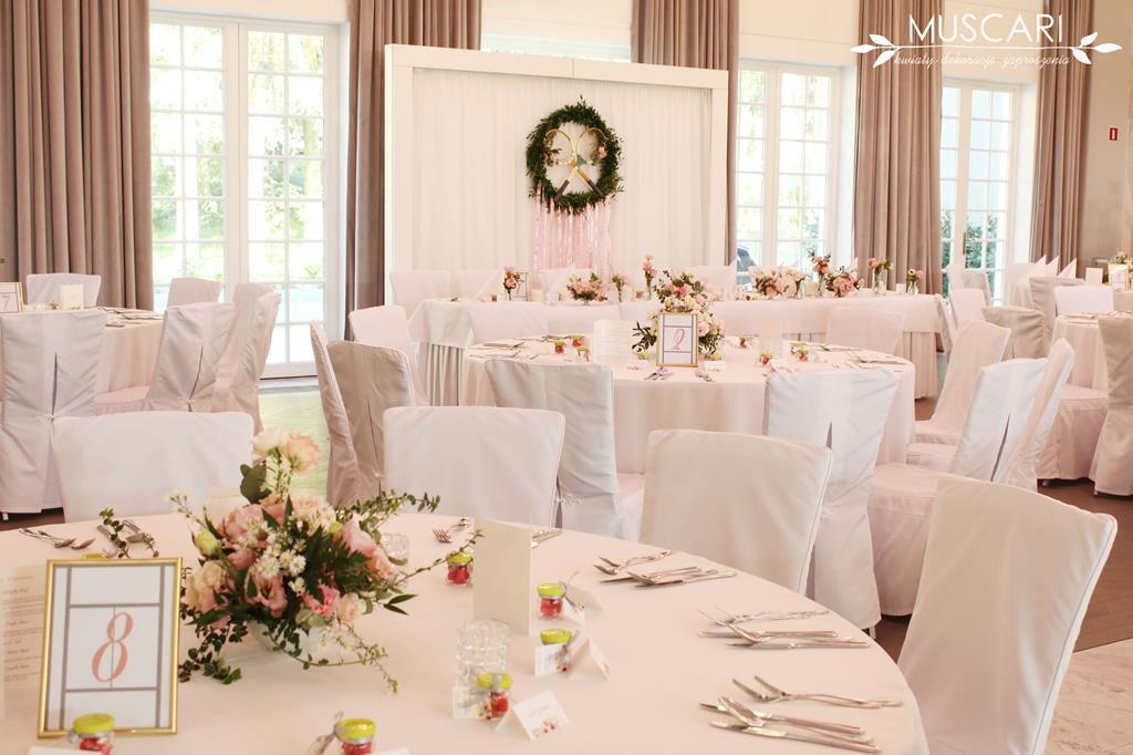 kwiaty na stołach weselych - w tle stół pary młodej