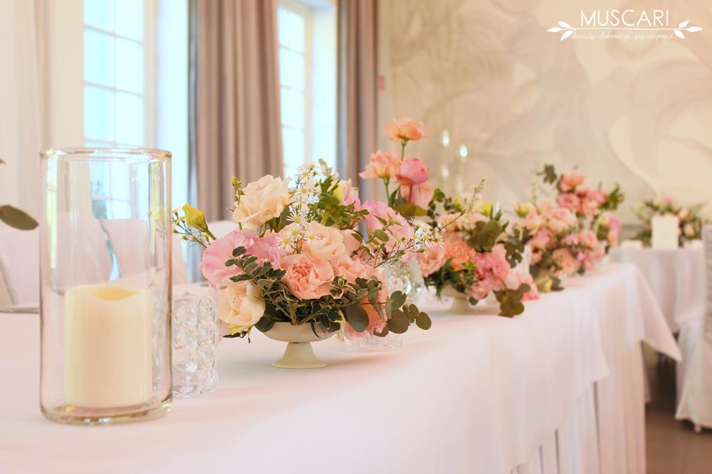 świece i bukiety kwiatów na stole młodej pary