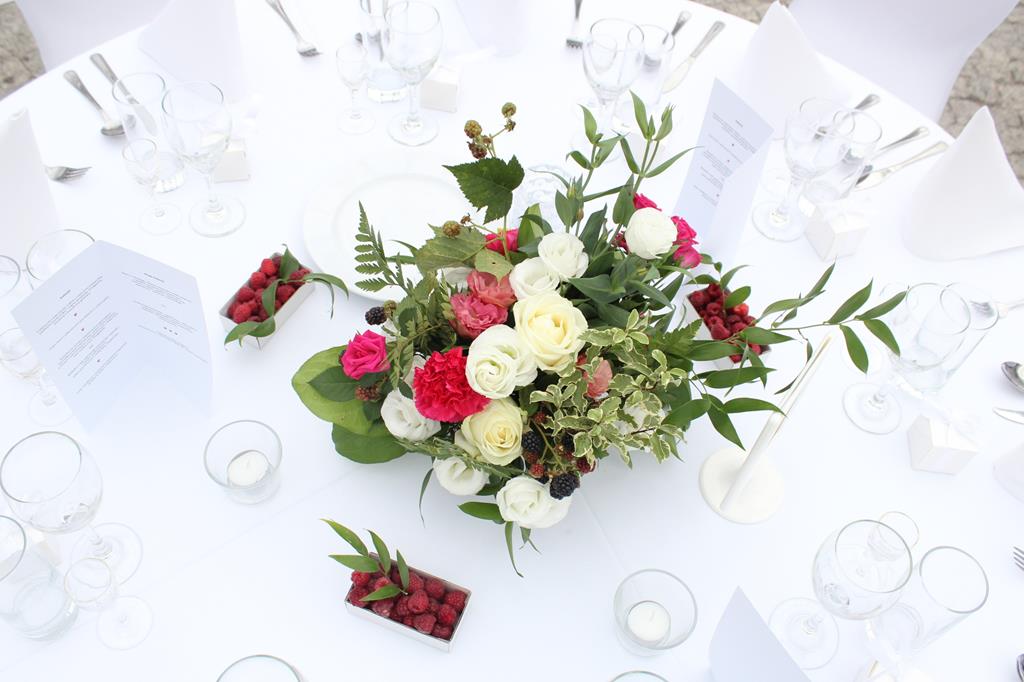 dekoracja stołu na wesele - róże, eustomy, goździki, maliny i zieleń w niskiej kompozycji