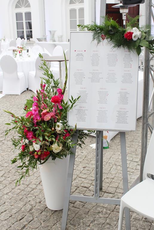 kompozycja z kwiatów i zieleni i ozdobiony table plan