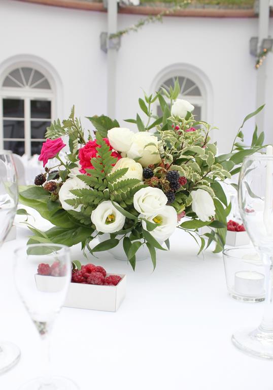 kwiaty, zieleń i maliny w kompozycji na stole [wesele w Forcie Sokolnickiego]
