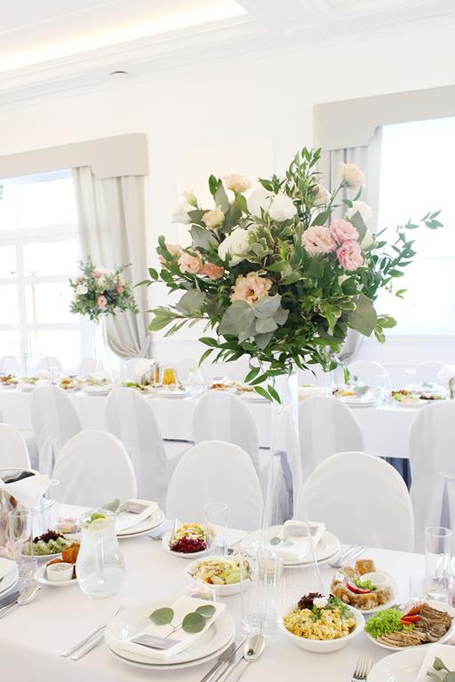 kwiaty i zieleń na stołach gotowych na wesele