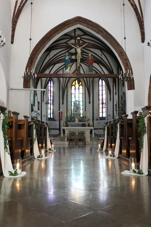 zieleń i białe sukno zdobiące ławki w kościele na ślub