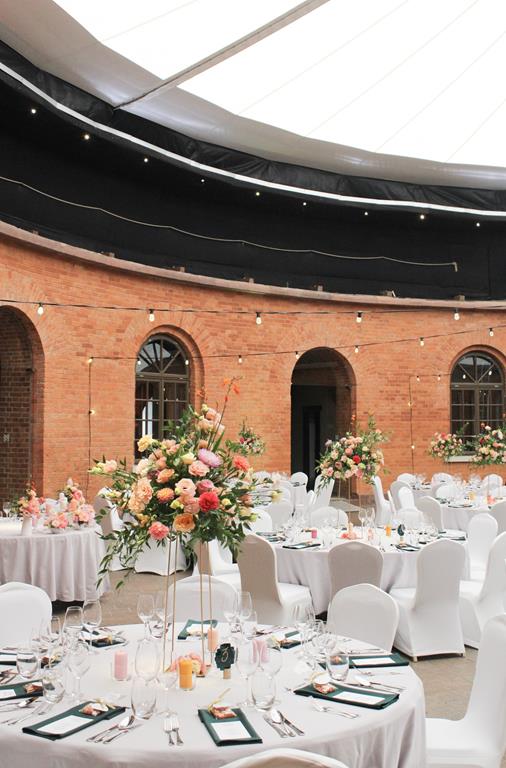 kolorowe wesela forteca - stoły ozdobione pastelowymi kwiatami na wysokich geometrycznych stojakach