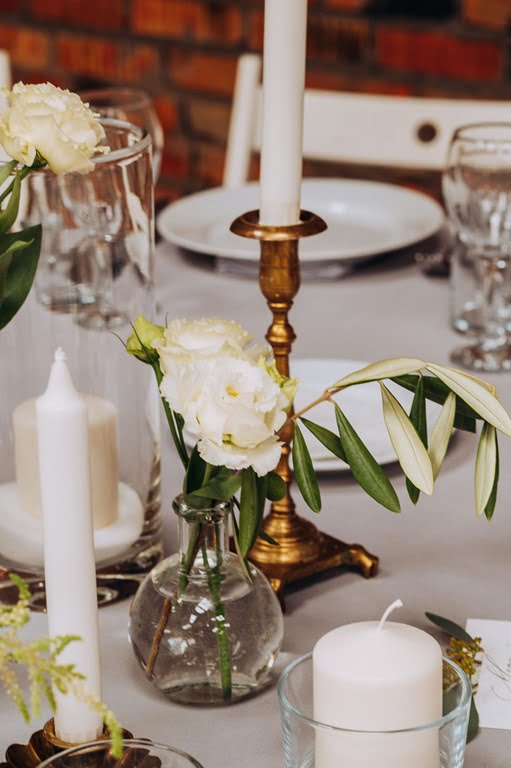 białe kwiaty i złote świeczniki w dekoracji stołu na wesele