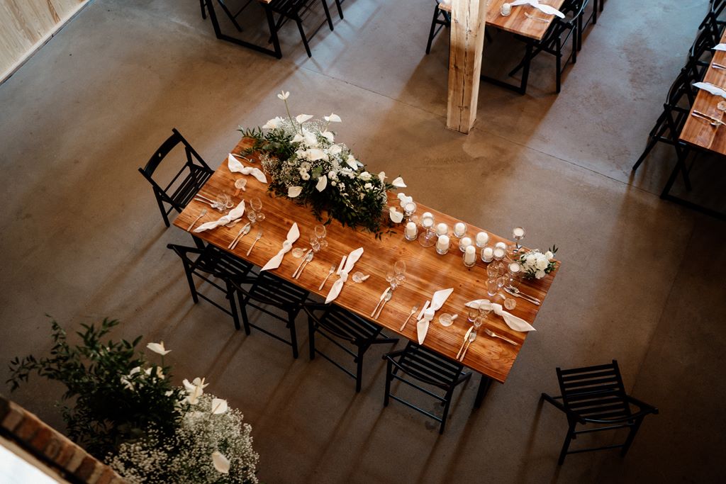 stół pary młodej udekorowany kompozycją z kwiatów anturium i zieleni oraz świecami - stół bez obrusa na weselu