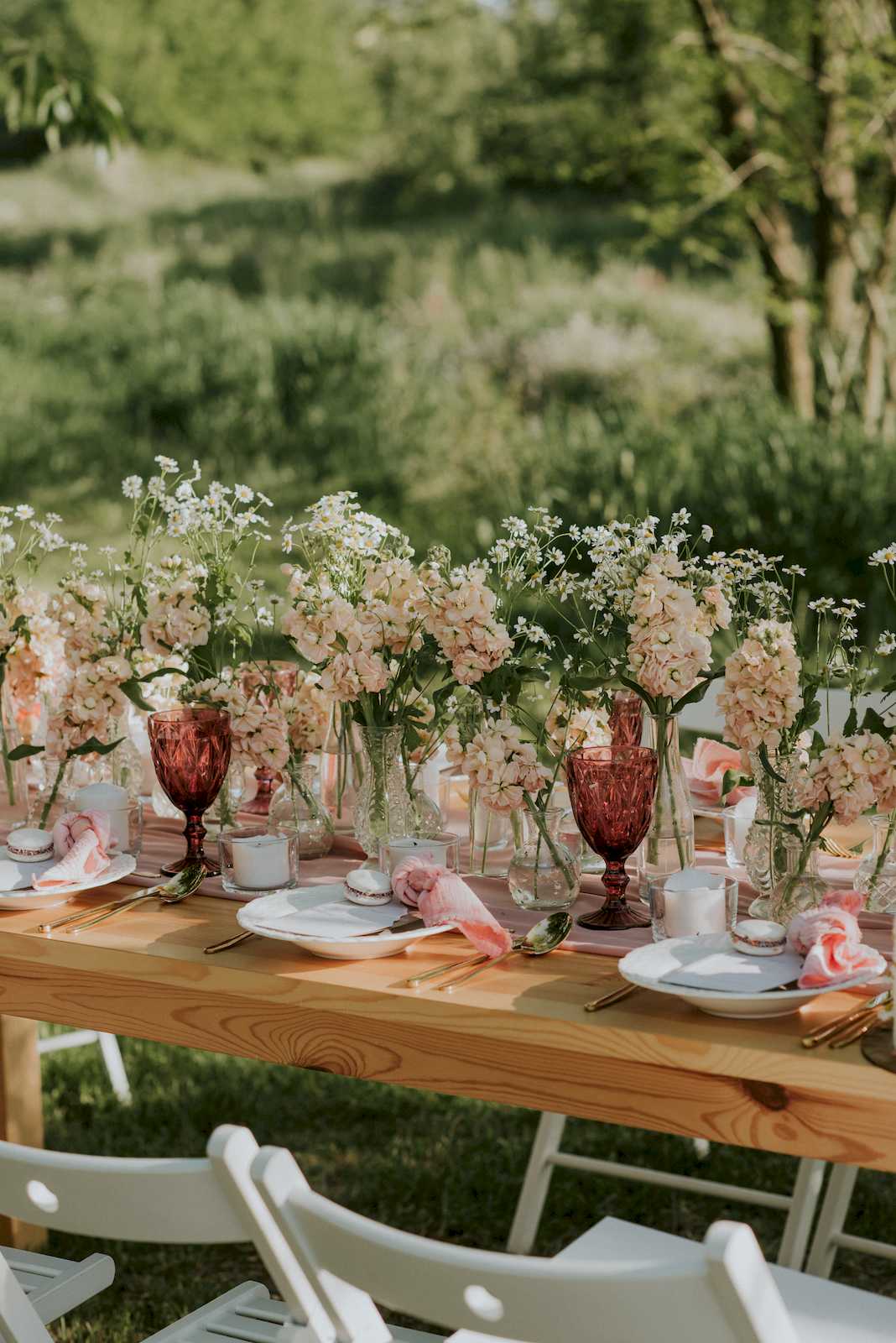 bukiety kwiatów w sielsiej dekoracji stołu weselnego