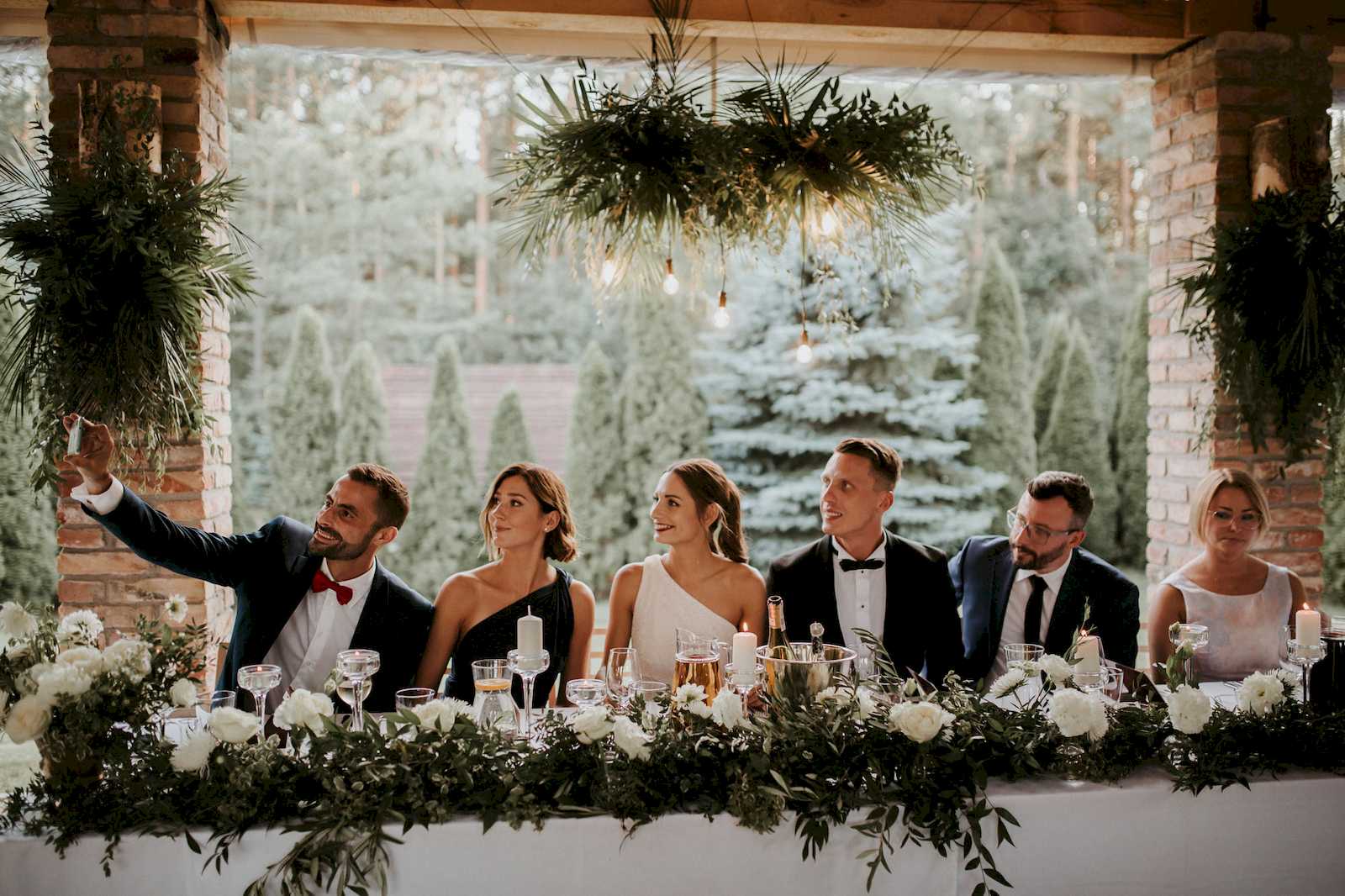 para młoda wraz ze świadkami przy stole podczas wesela