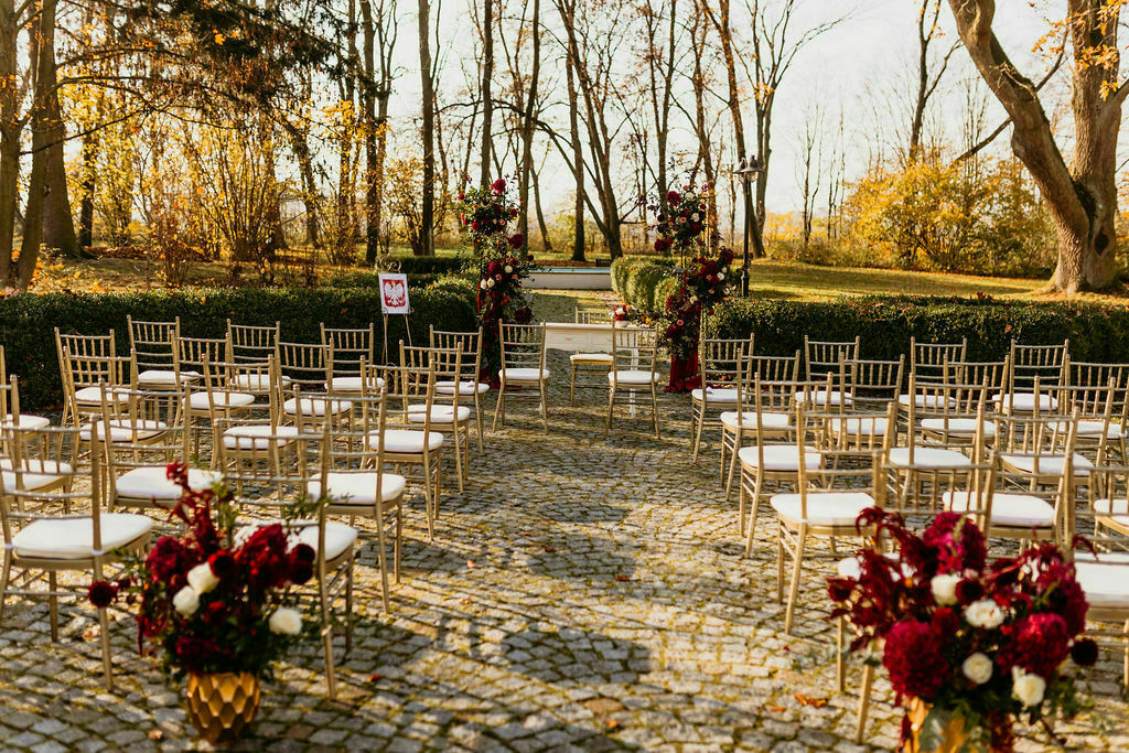 ślub cywilny w plenerze - bordowe kwiaty tłem dla ceremonii